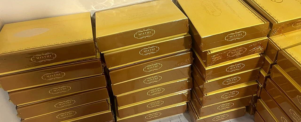 Stacks of shrink-wrapped Misthi gift boxes, packed for a large order